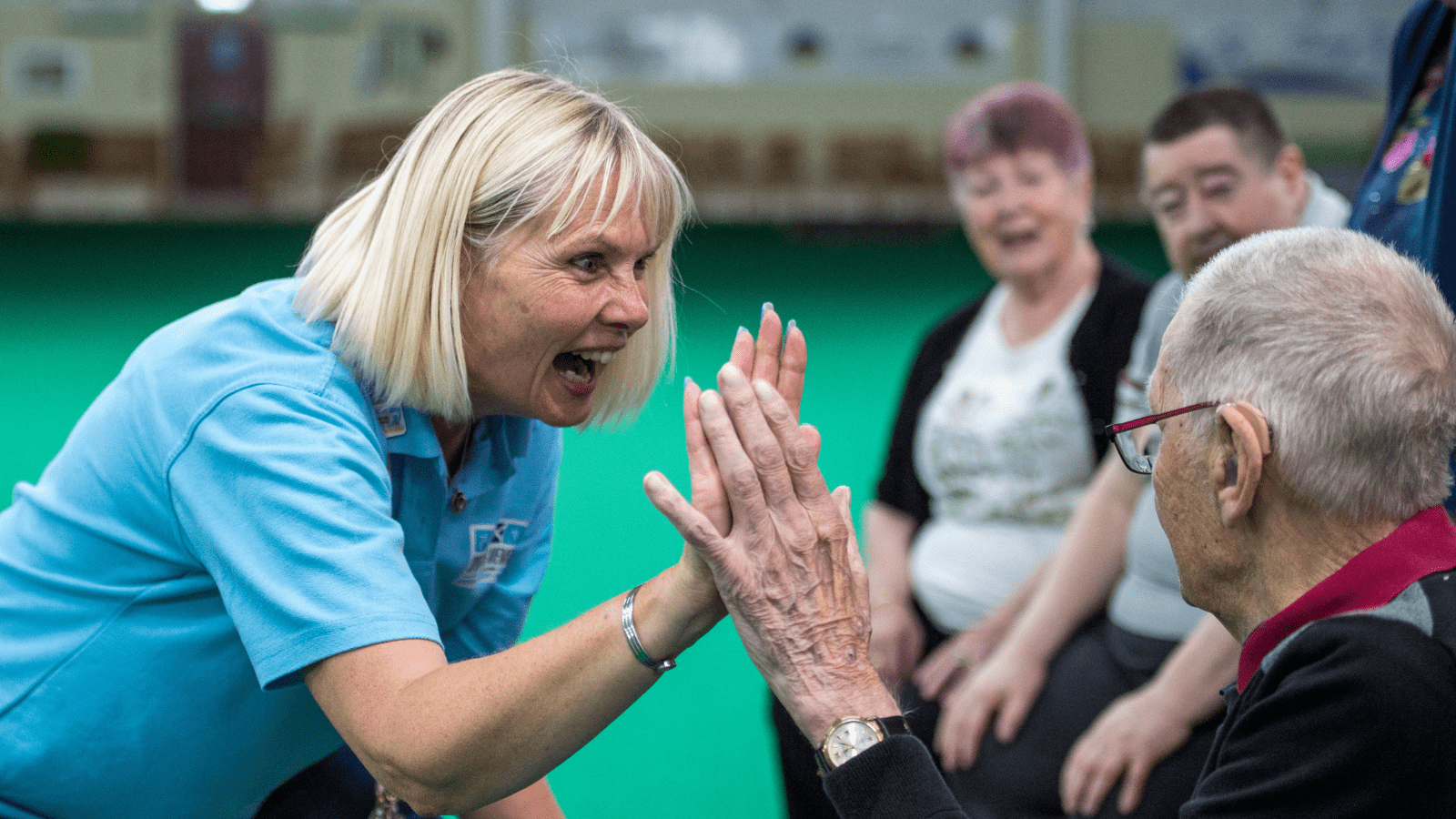 Volunteer high-fiving Sporting Memories Club Member